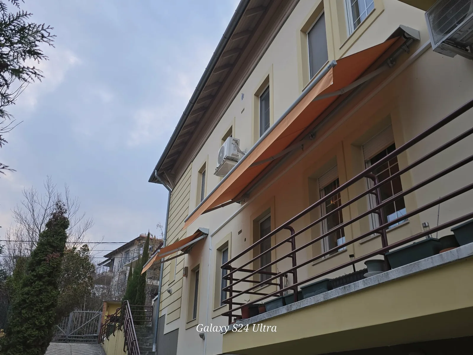 narancs színű napellenzők társasházi ablakok felett